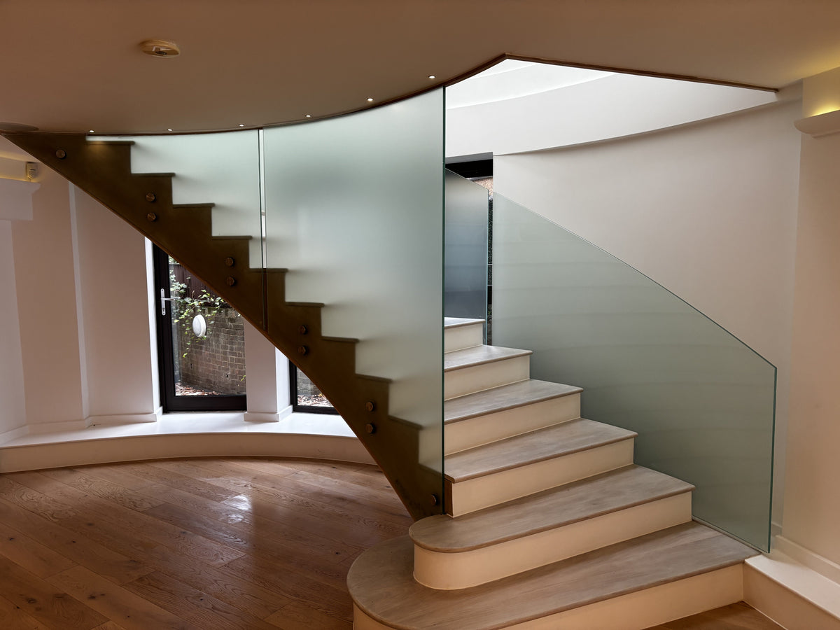 Frosted window film applied to the glass of a large staircase in a luxury home.