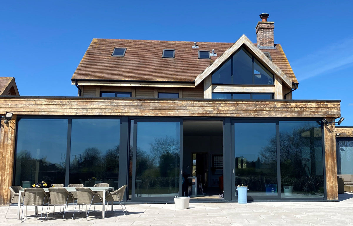 A modern home with a glass frontage featuring tinted window film to help reduce glare.
