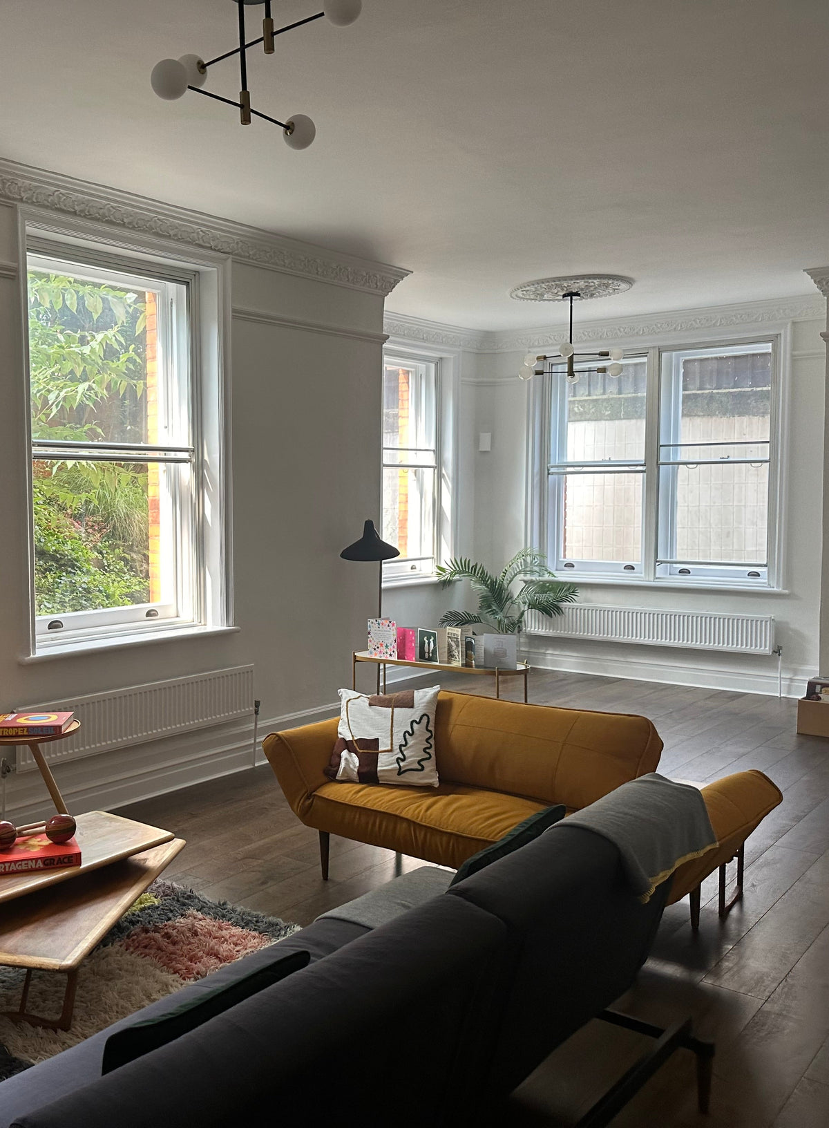 An internal view of a modern living space with windows that have clear safety window film applied, allowing a view to the outside. 