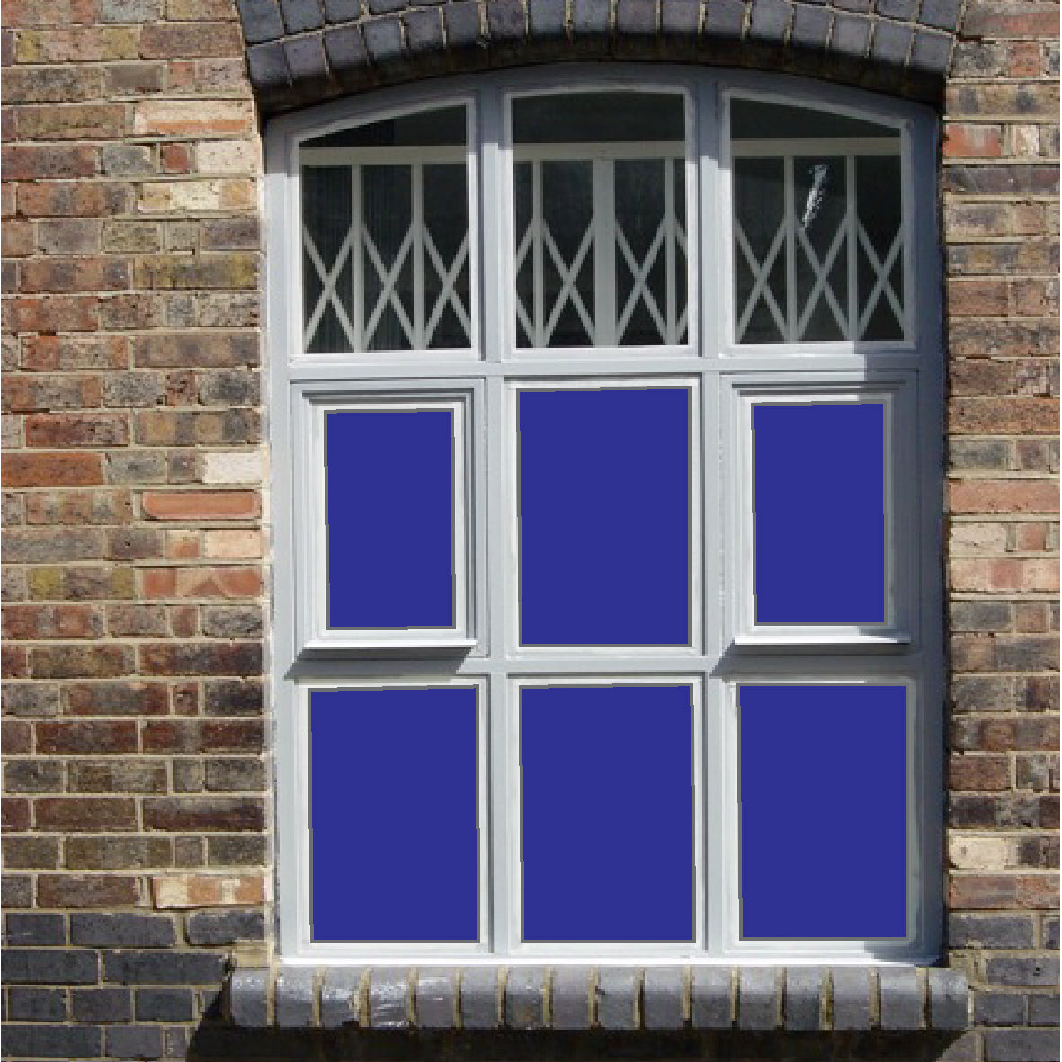 Window set into a brick wall, split into six panes with solid coloured blue window film applied to each pane