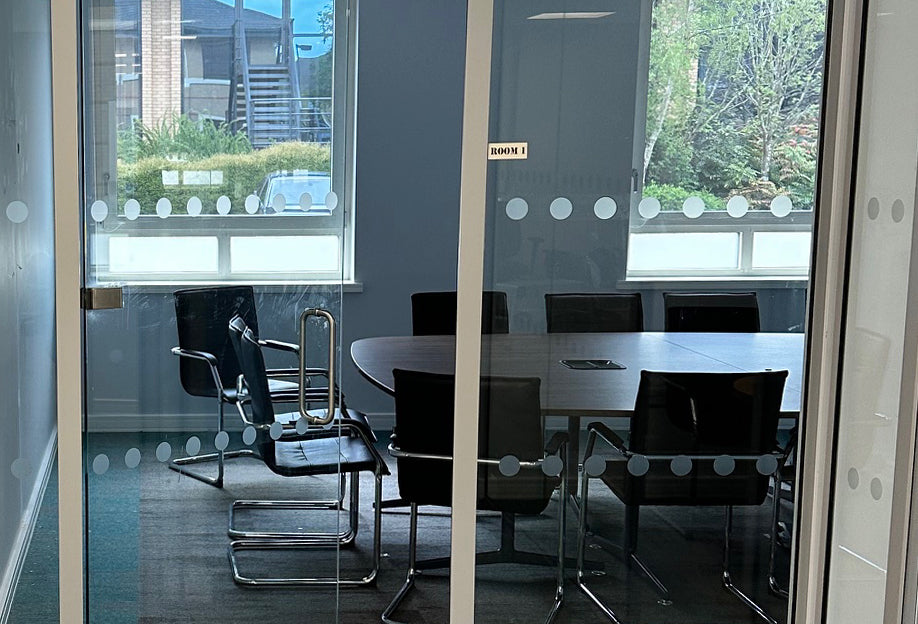 Glazed partition featuring glass manifestation dots, created from frosted window film.