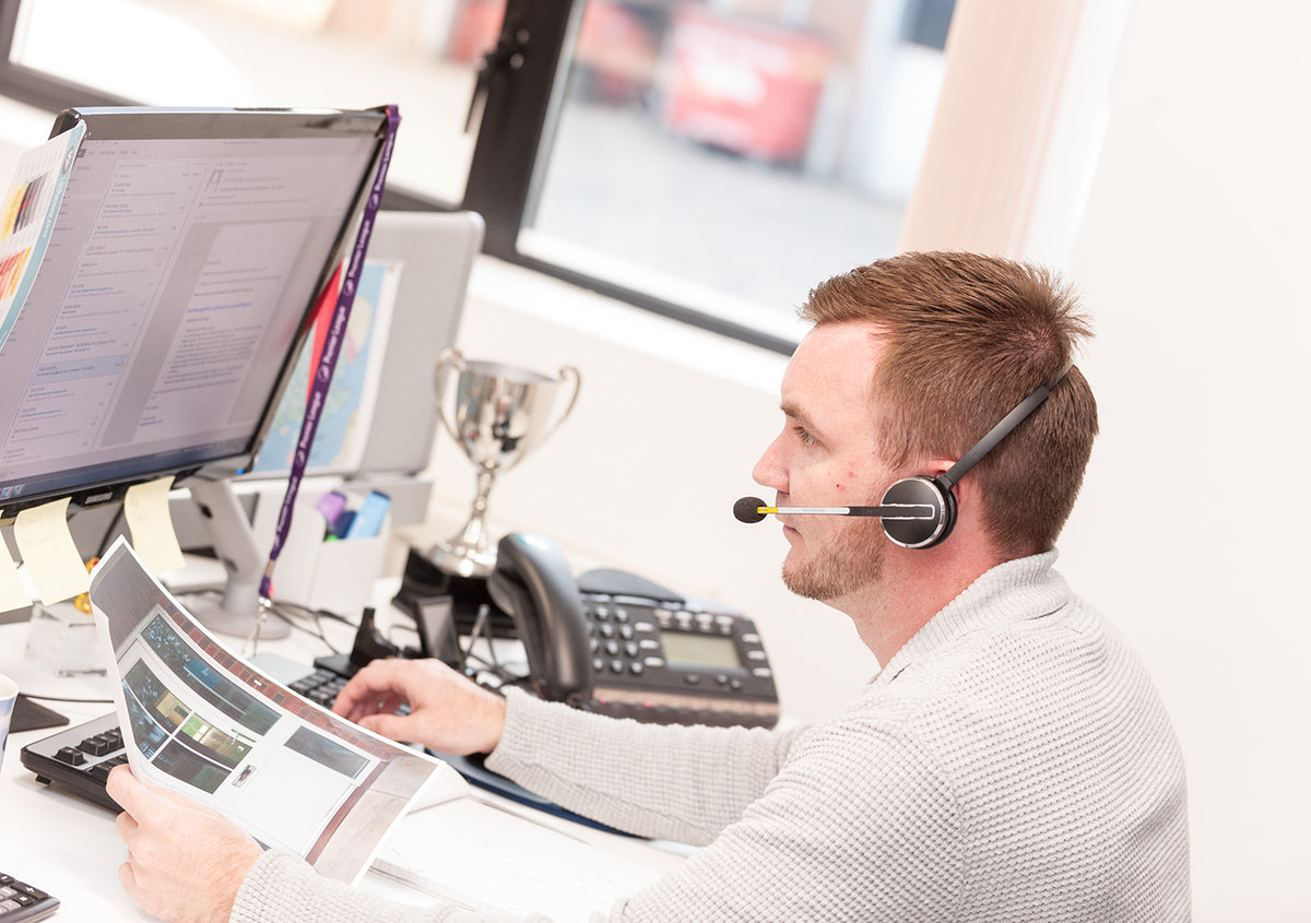 An employee at The Window Film Company in England, talking to a customer on the phone.