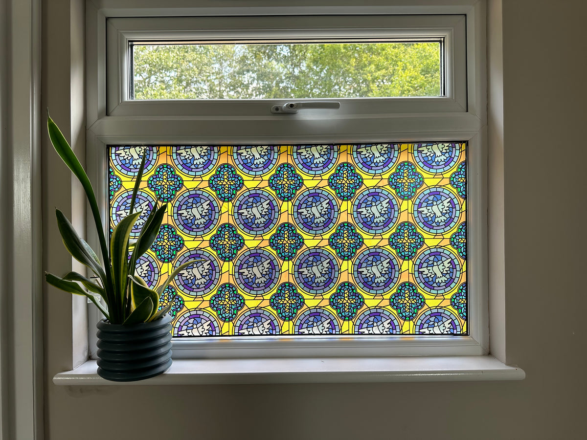 A window in a home with full colour stained glass effect window film applied to the bottom pane for decoration and two way privacy.