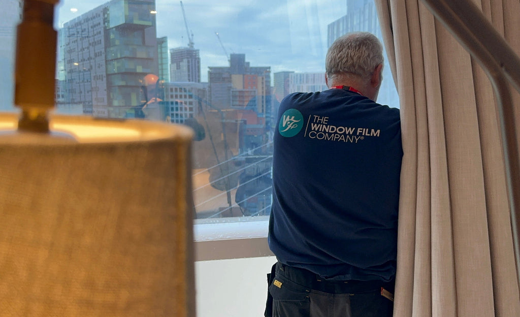 An installer from The Window Film Company applies film at the Lowry Hotel in Manchester.
