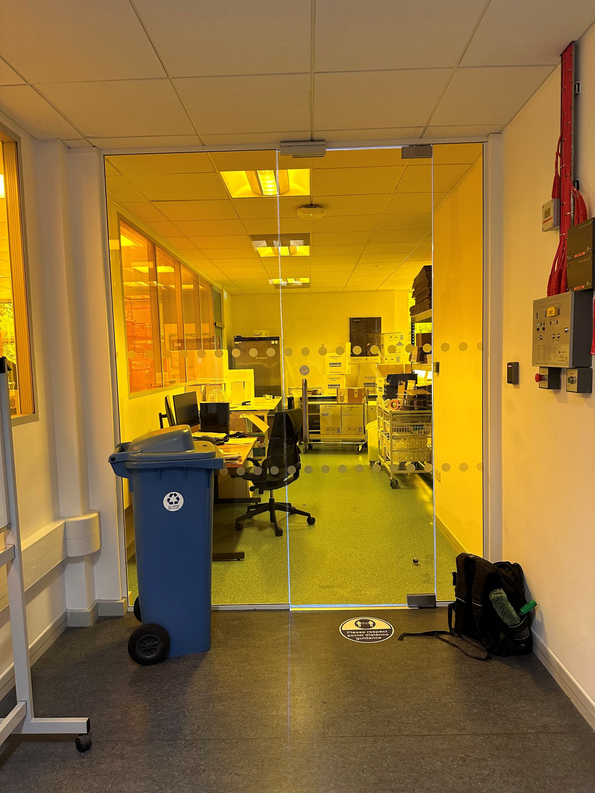 Glass partition with Amber 81 UV protection window film applied to the glazing, giving the glass an amber colour without blocking the view through the glass and into an office space. 