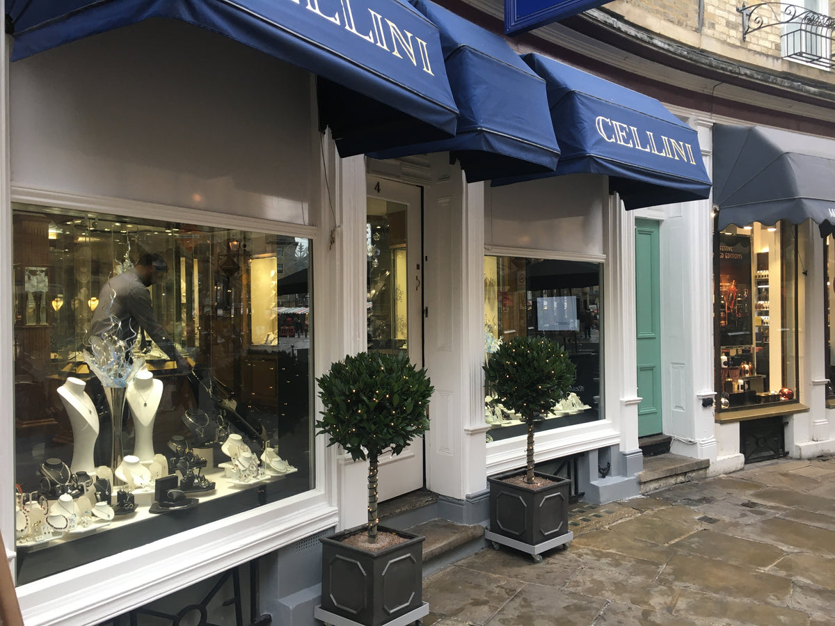 Cellini store front with jewellery display and blue awnings; anti-graffiti window film has been applied to the window film although this is undetectable to the naked eye. 
