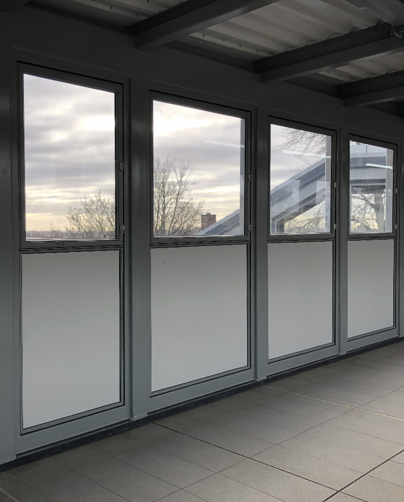 A glazed bridge over a rail line which has had anti-graffiti window film applied to reduce the risk of damage.