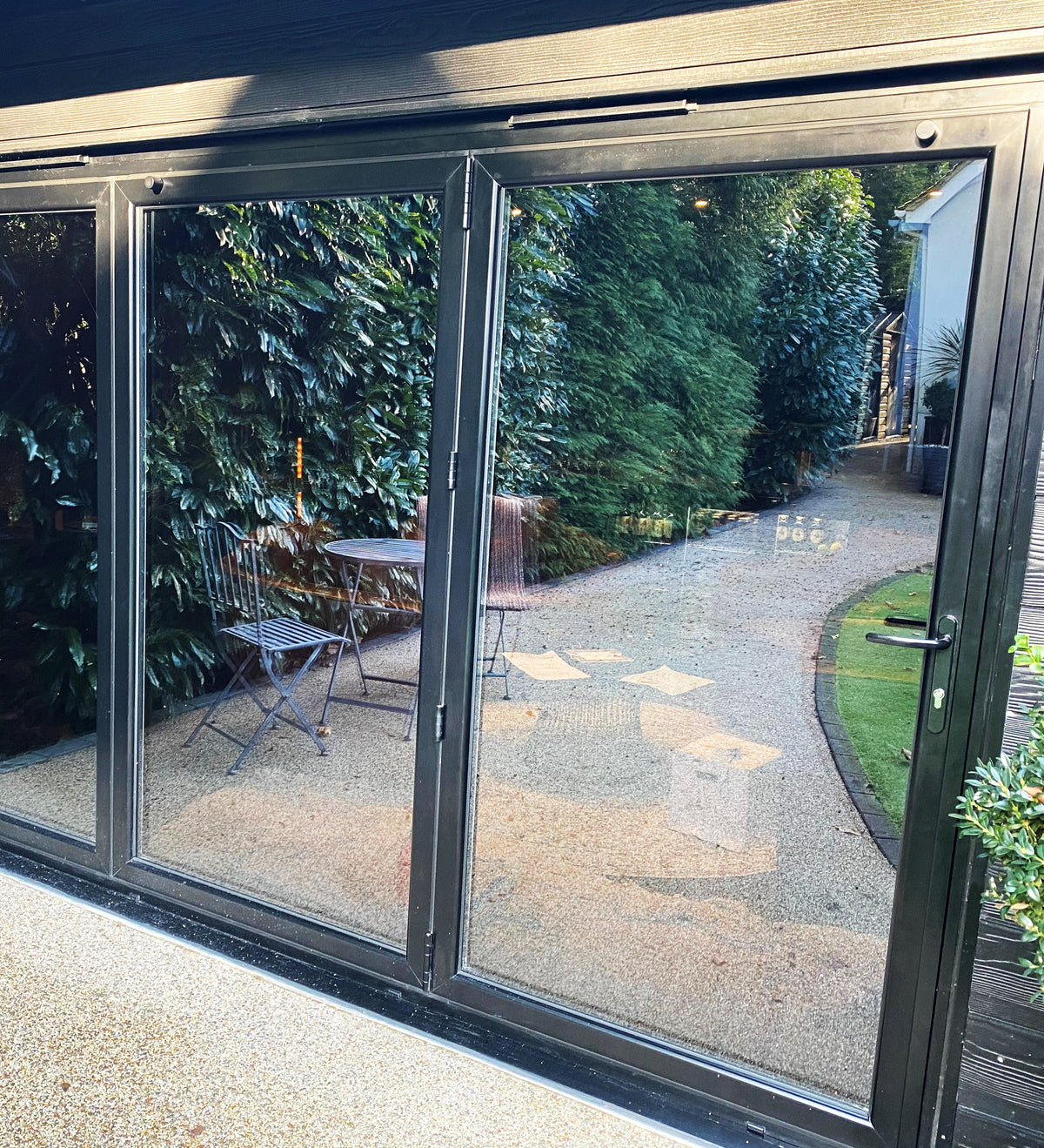 Garden room with large patio doors, the doors have had glare reduction window film applied, delivering a stylish black finish. 