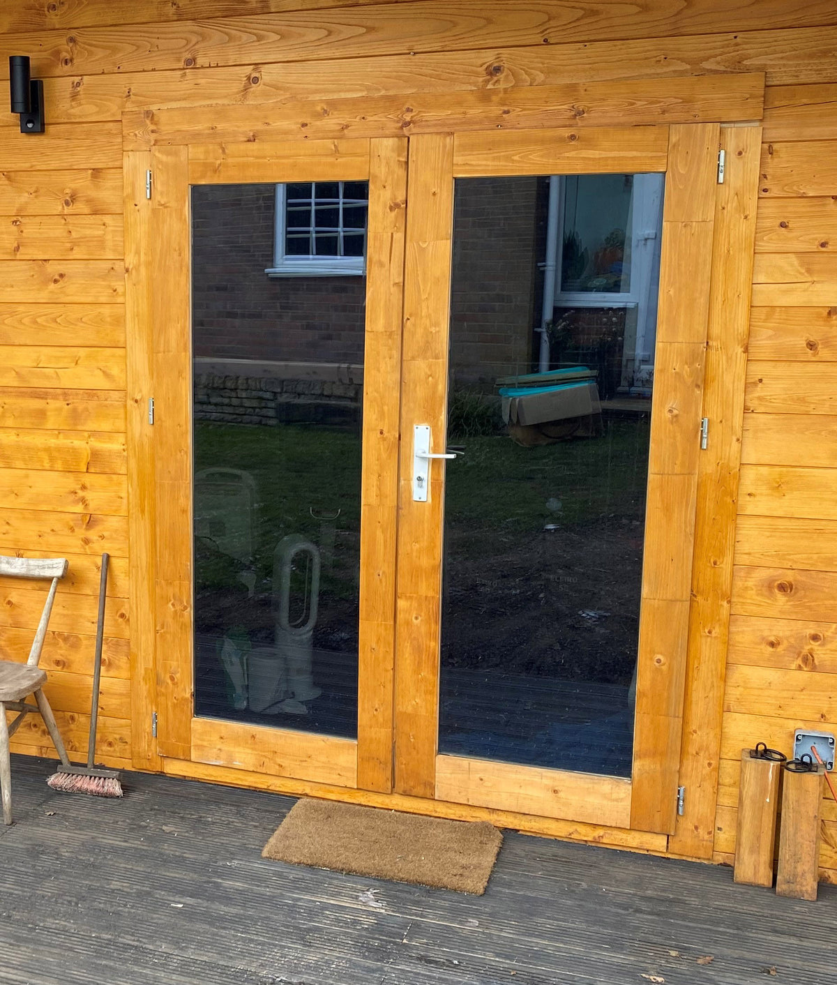 Wooden garden room with glazed patio doors featuring Black pearl tinted window film for glare reduction and UV protection. 