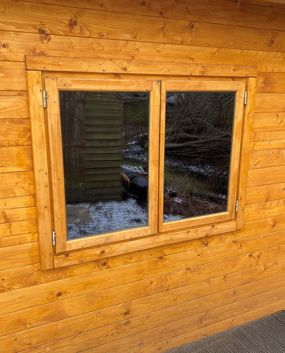 Wooden cabin with windows featuring Black pearl tinted window film for glare reduction and UV protection. 