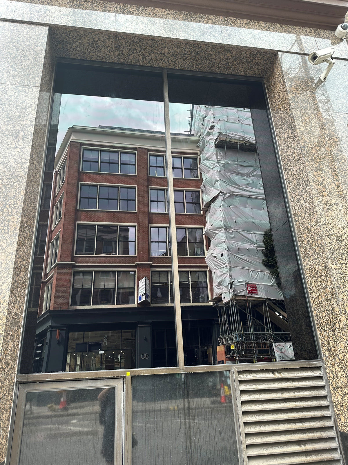 External view of a commercial building with a large window; blackout privacy window film has been applied to the glass to block the view in.