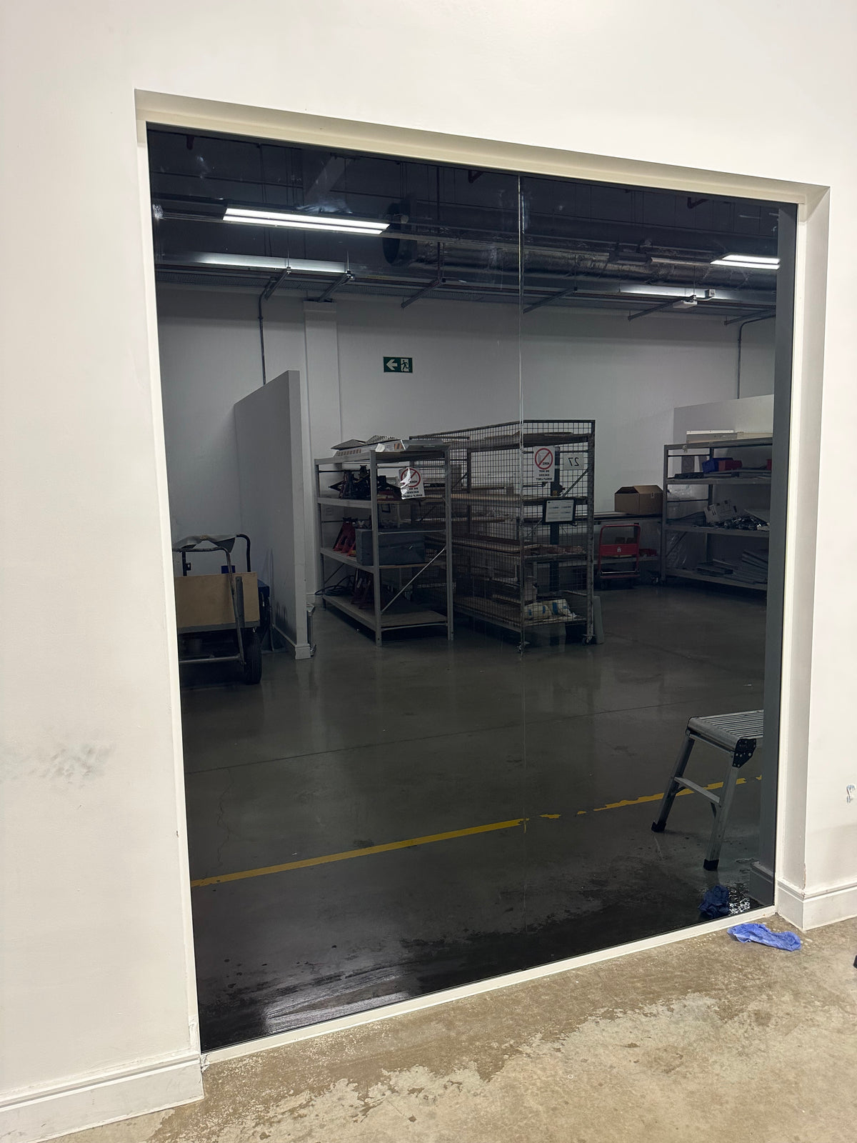 Large glass panel in a warehouse featuring blackout privacy window film to block the view from both sides of the glass.
