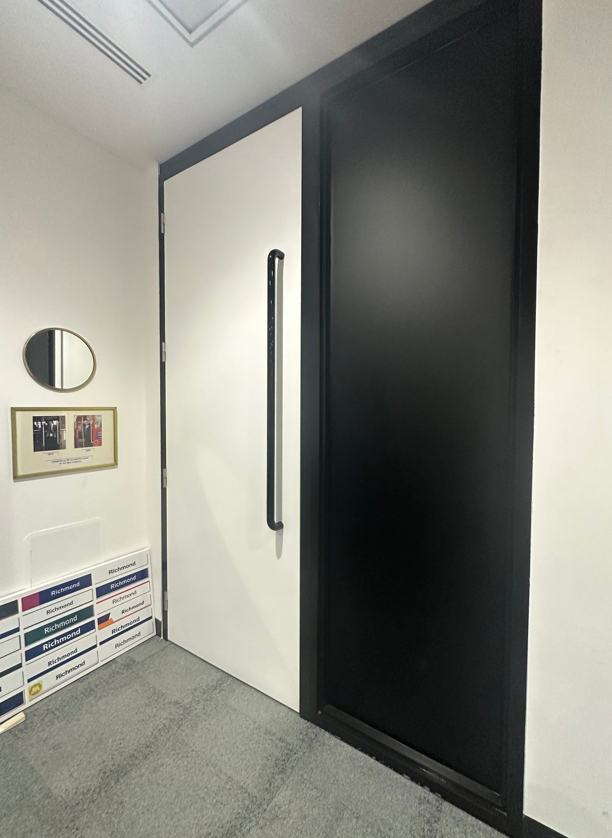 Internal shot of a glazed panel. Blackout privacy window film has been applied to the panel, changing the colour of the glass to a solid black and preventing a view from both sides of the glazing. 