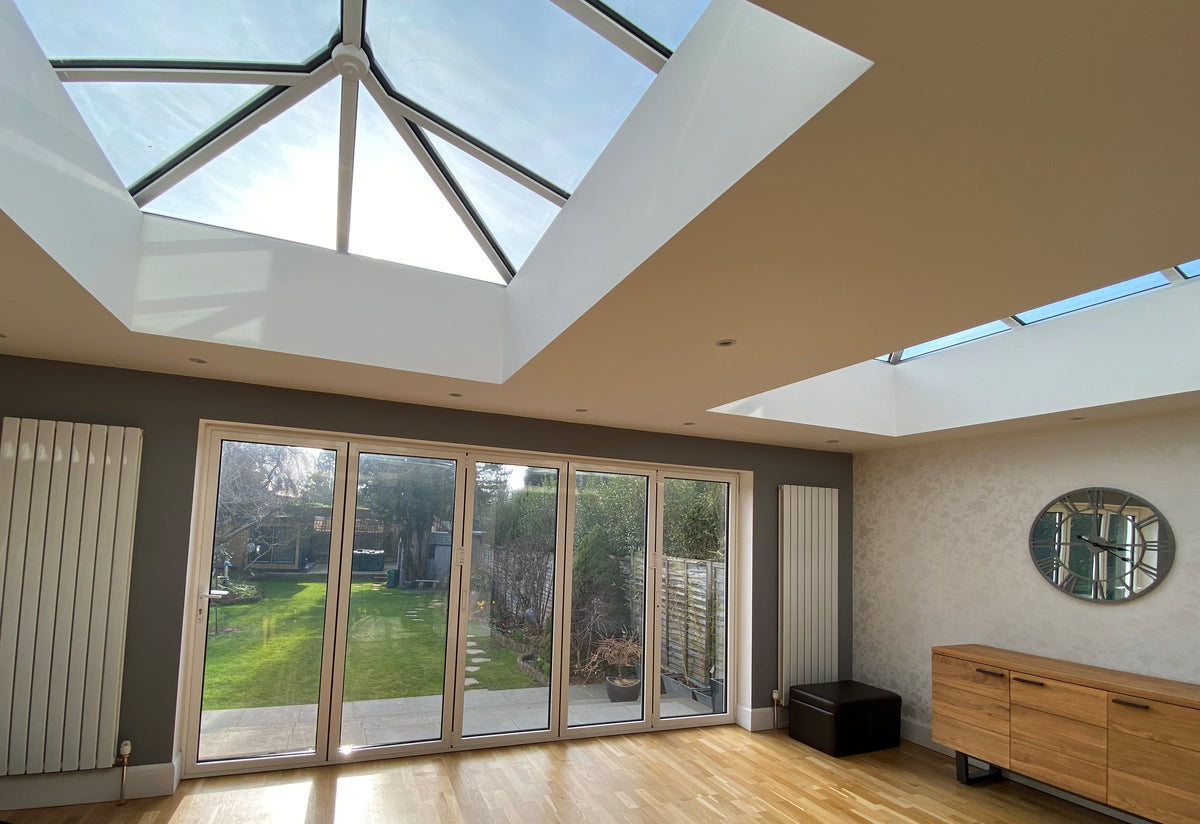 Modern room with large skylights and glass doors leading to a garden. Fade reduction window film has been applied to the glazing. 