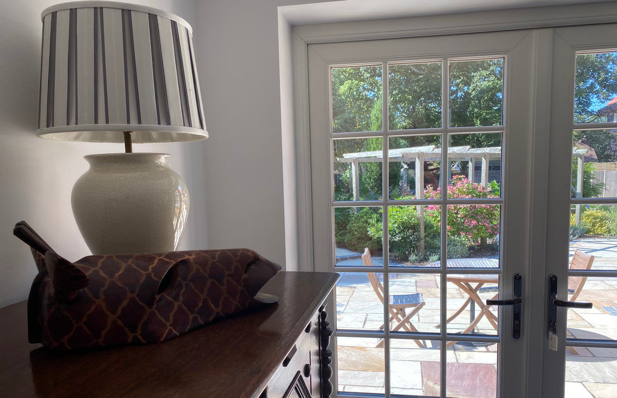 Glass doors in a residential property, looking out onto a garden. Fade reduction window film has been applied to the glass.