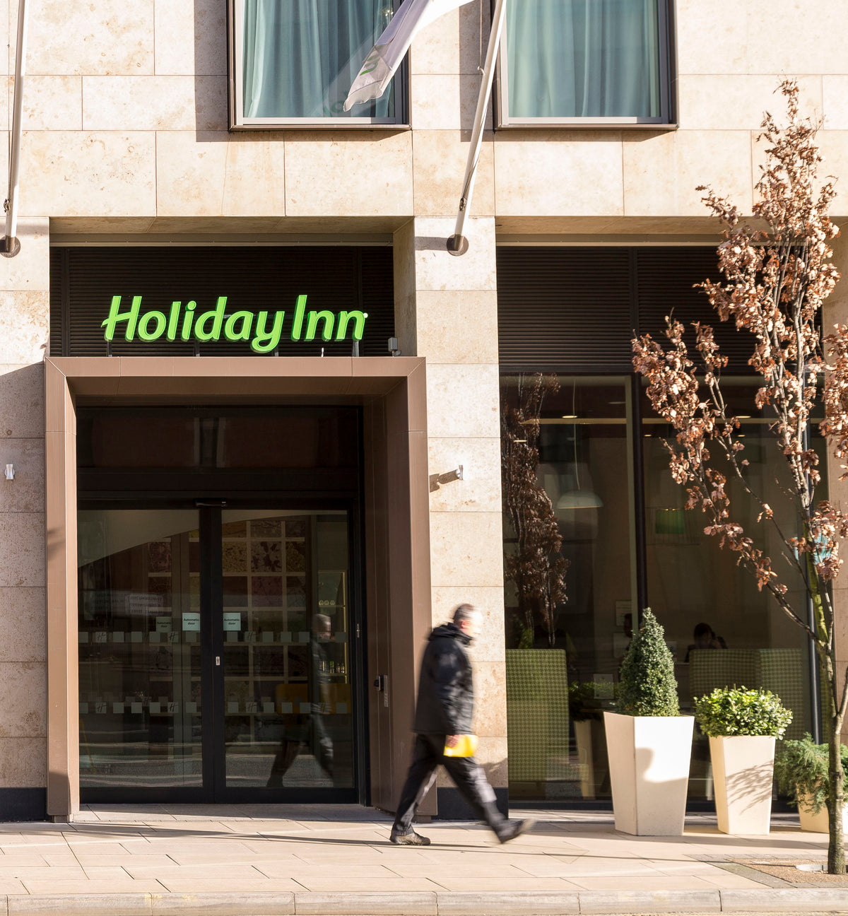 An external view of a Holiday Inn hotel, with Clearplex glass protection window film applied to the large windows.  