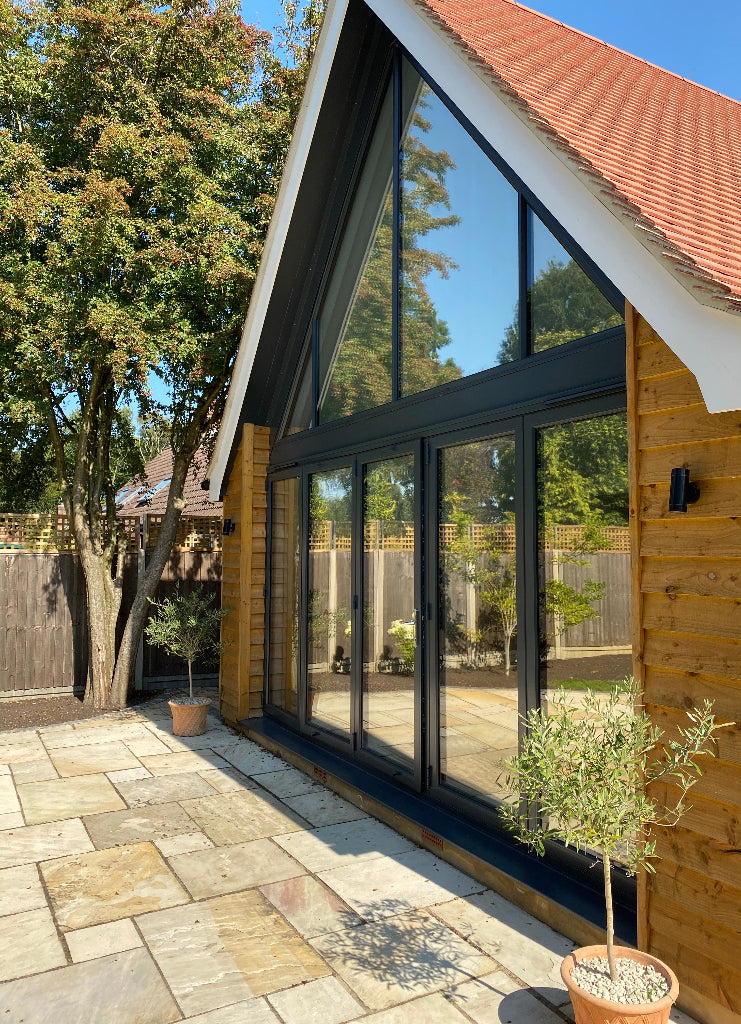 Solar control window film applied to the shaped window and bifold doors of a modern house.