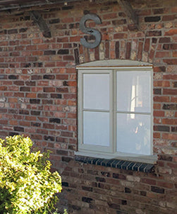An external view of a residential property window, with contra vision privacy film applied, giving the glass a white appearance. 