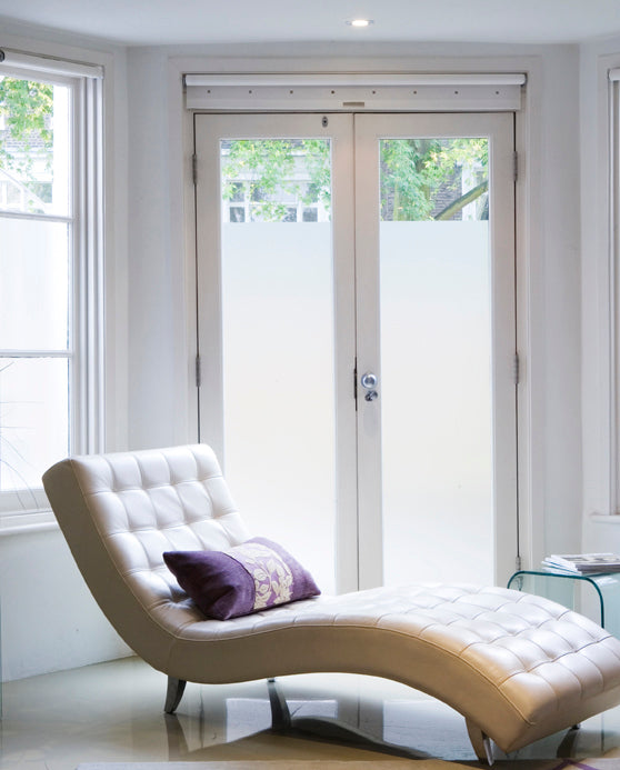An internal image of patio doors and windows, with a sofa in the foreground. The glazing has Crystal Etch frosted window film applied to deliver privacy. 