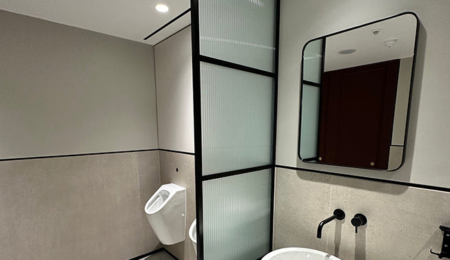 Evoke standard frost reeded window film applied to a modesty screen in a toilet.