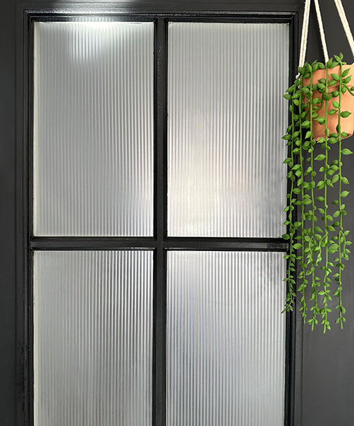 Four panes of glass with frosted reeded film for privacy.