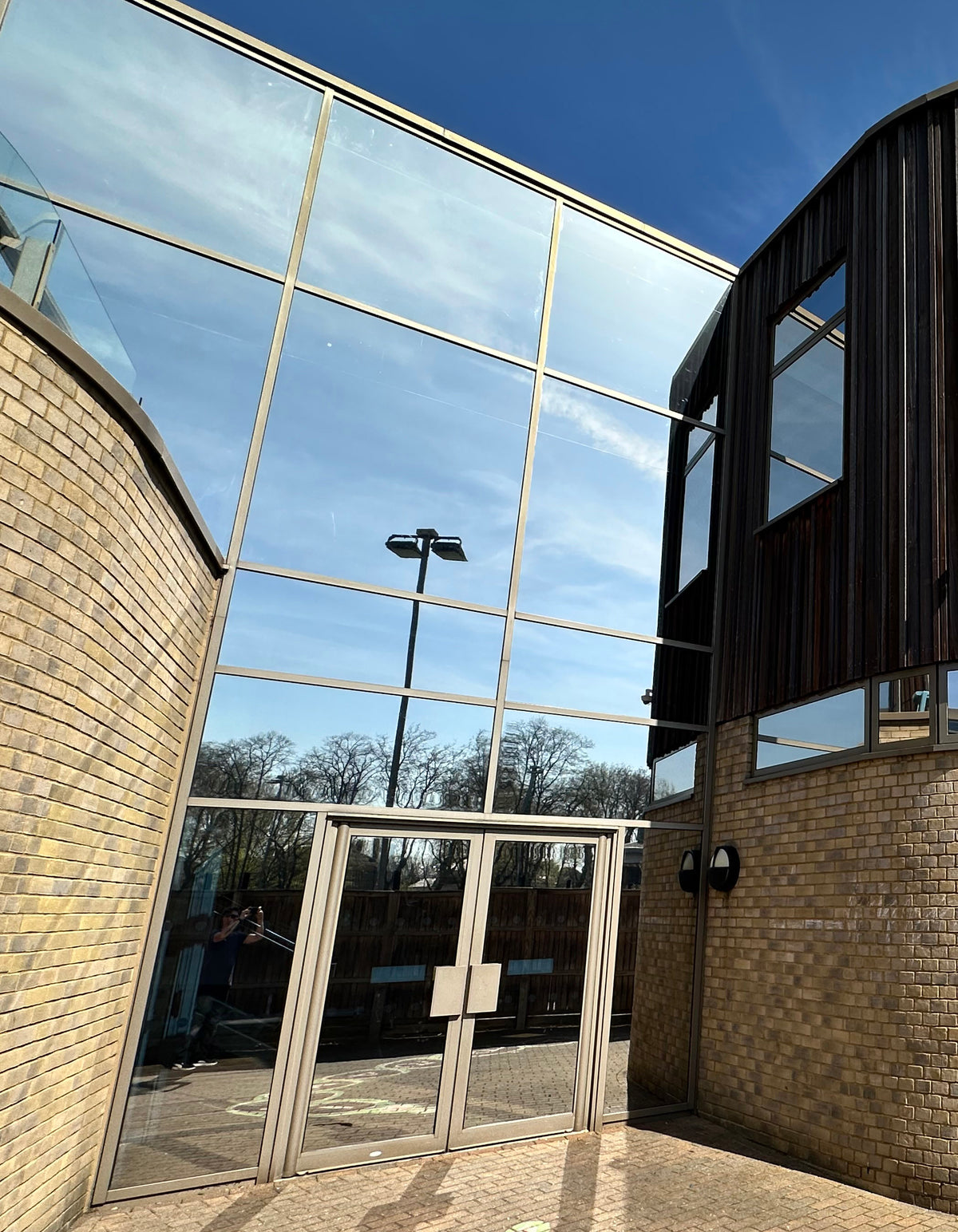 Modern building with large glass frontage. reflective solar control window film has been applied to the glazing.