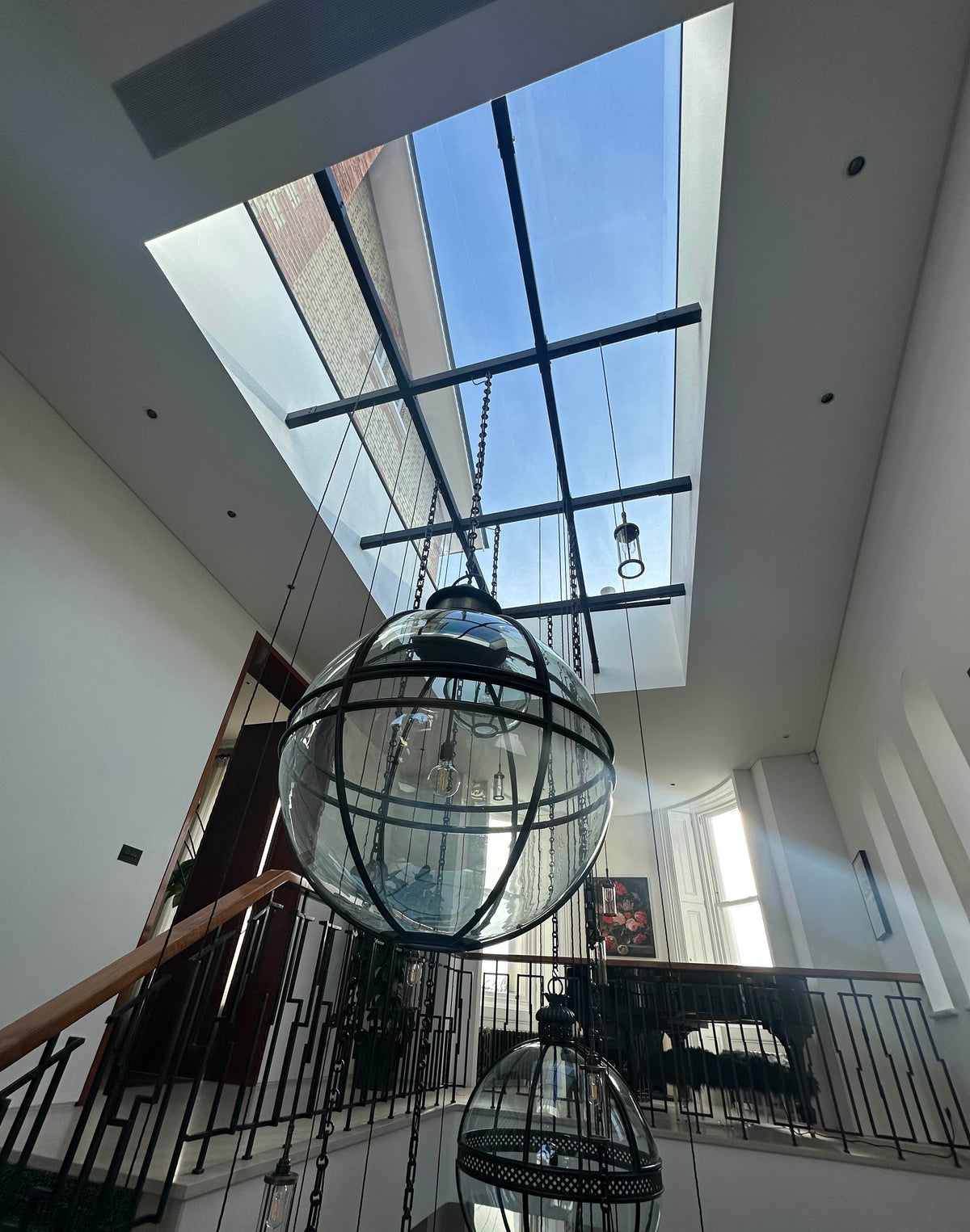 Internal view of a large glass rooflight over a grand staircase. External grade Light Reflective Silver window film has been applied to the glass to help reduce heat.