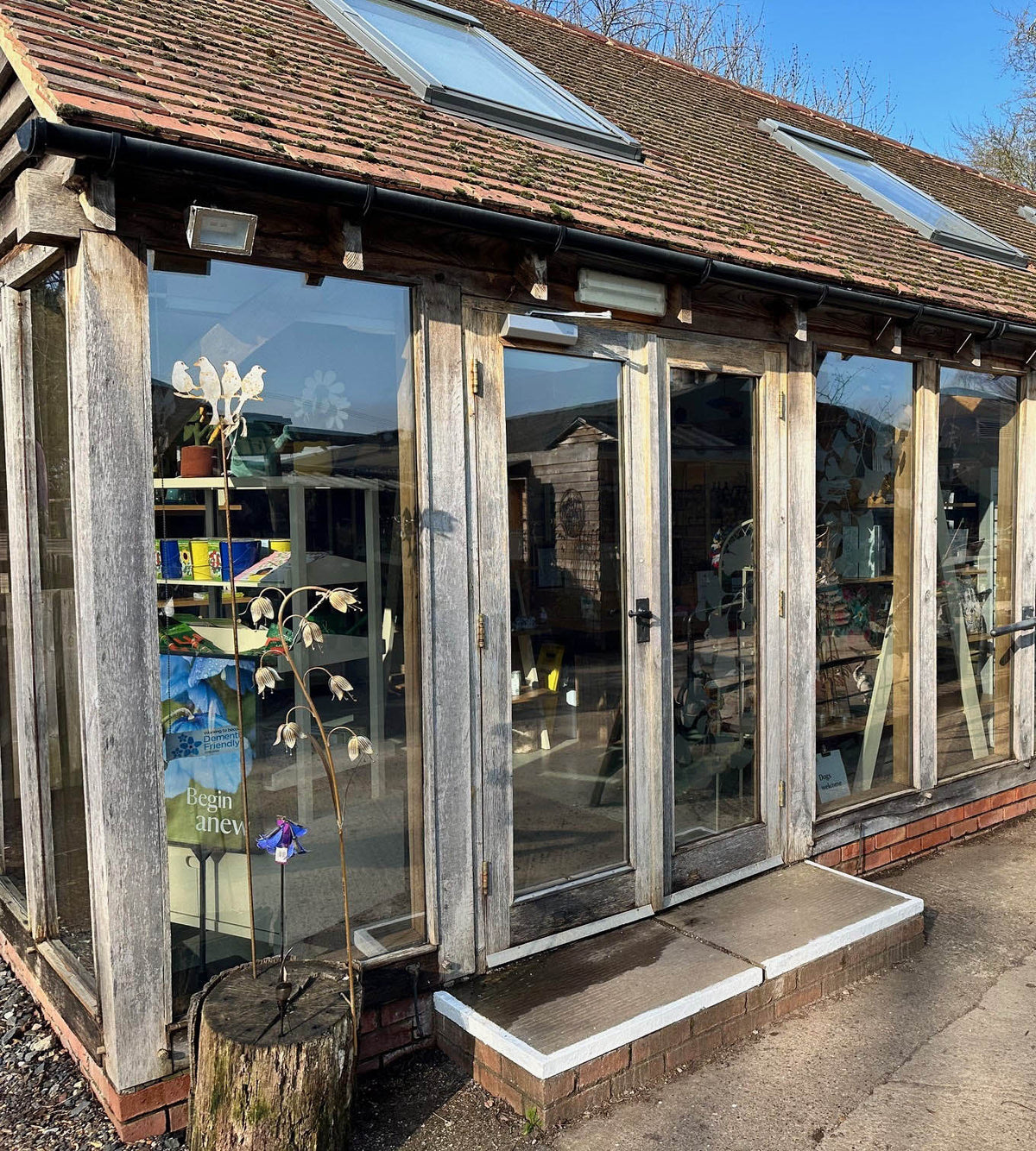 View of a storefront with wooden frames and glazed panels. The glass has Light Reflective Silver applied to the glass to help reduce heat and glare.