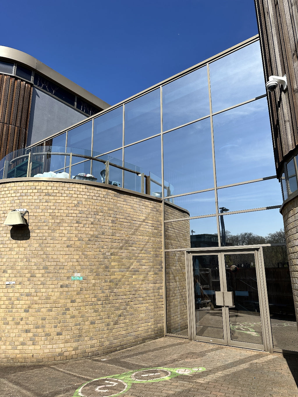 Modern facade of a school with reflective silver window film applied to reduce heat and glare.