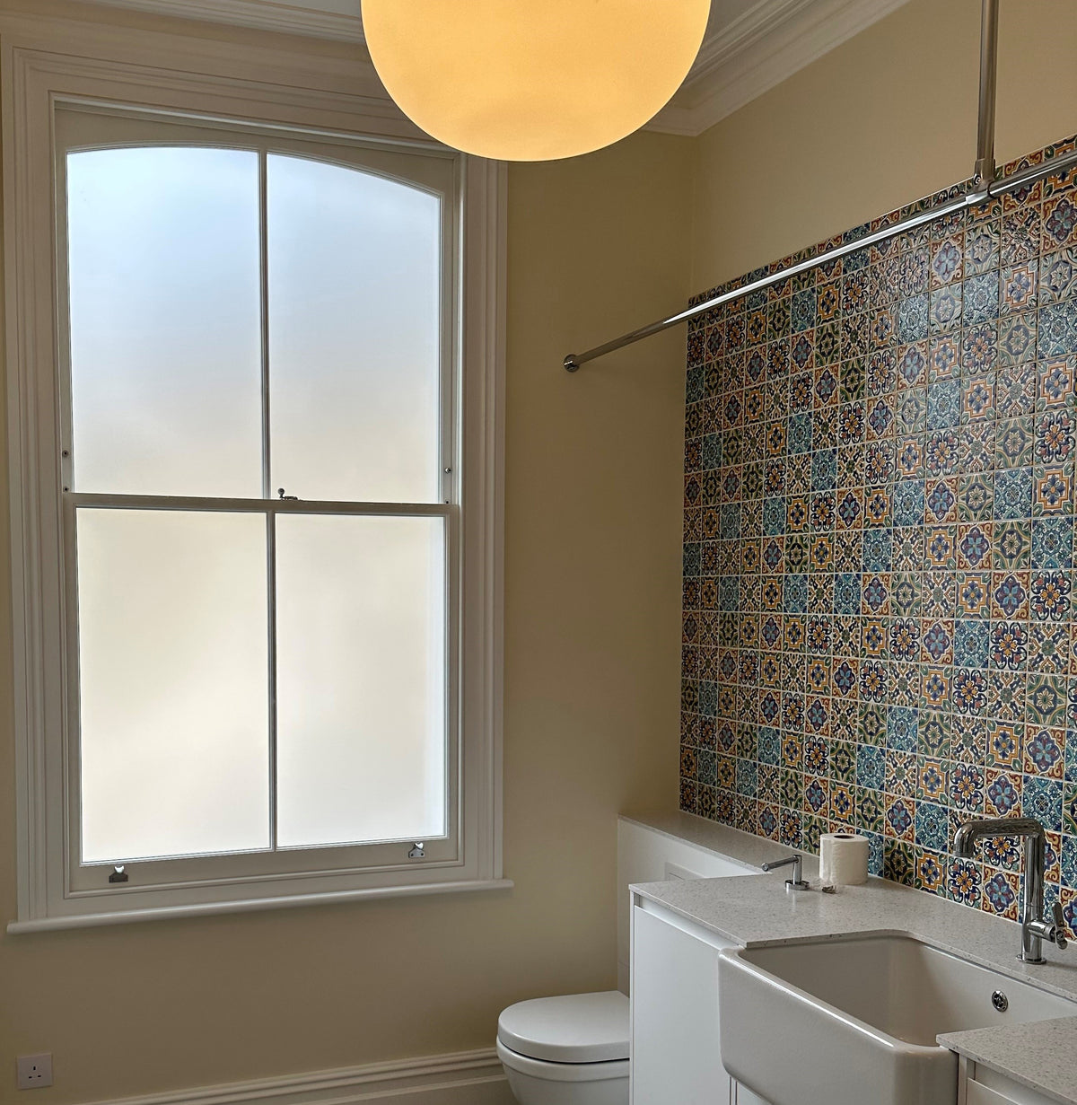 A bathroom toilet window which has had frosted window film applied to four panes of glass for privacy.