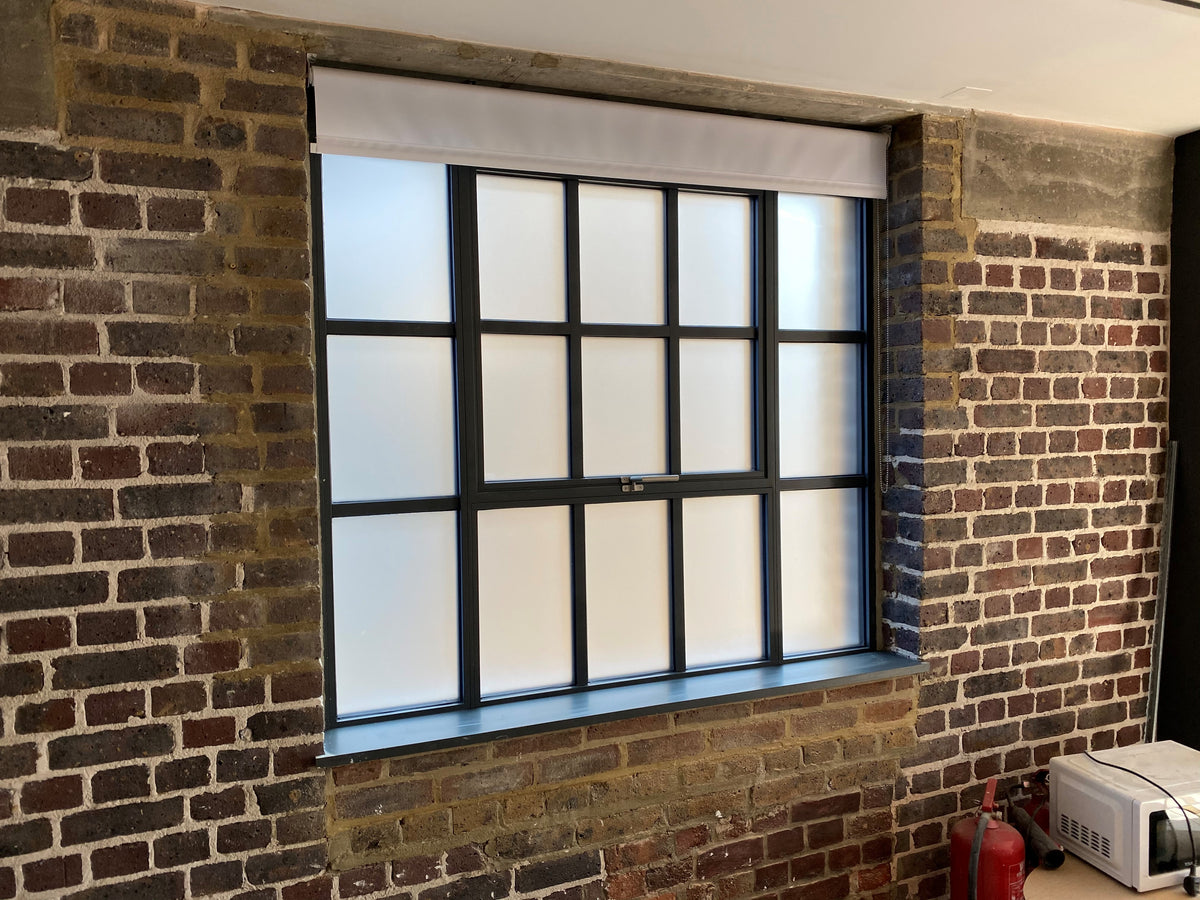 A window in a contemporary building. The window has had frosted window film applied to the panes, delivering privacy.