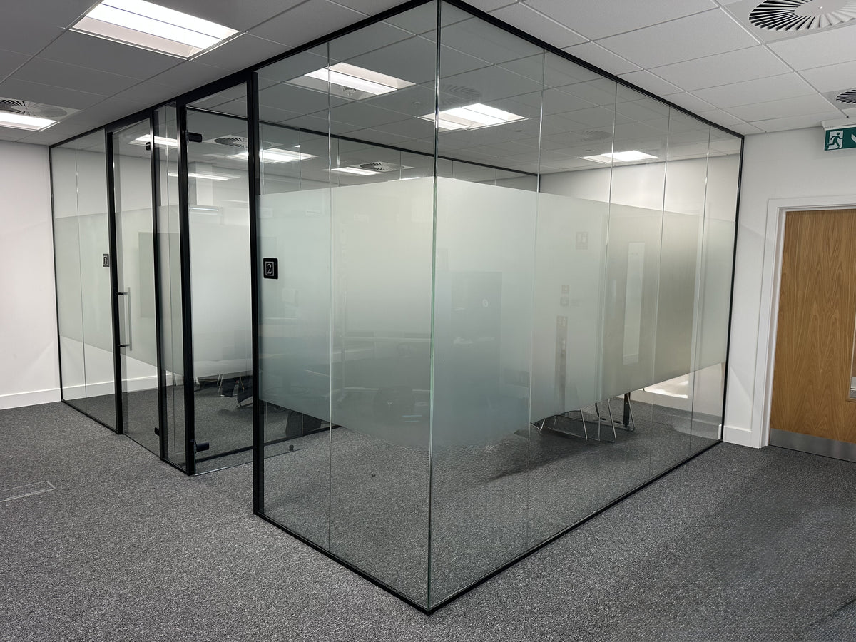 Glass office partition with frosted window film in a modern office setting.  The frosted film is cut into a 1200 mm central band.