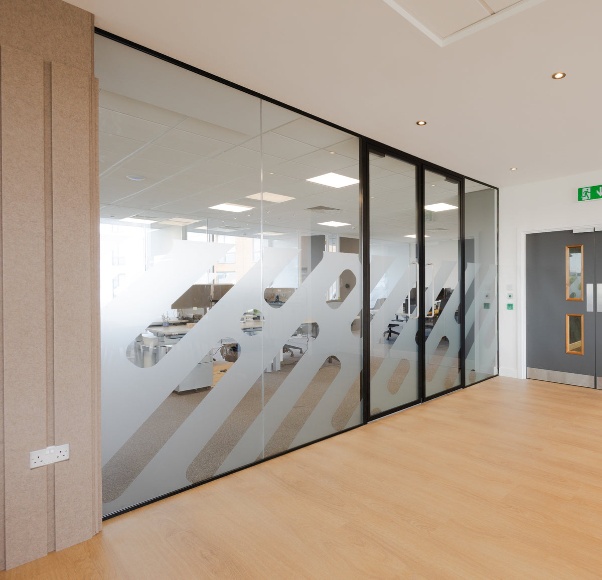Modern office interior with glass partition that as computer cut manifestation on the glazing.