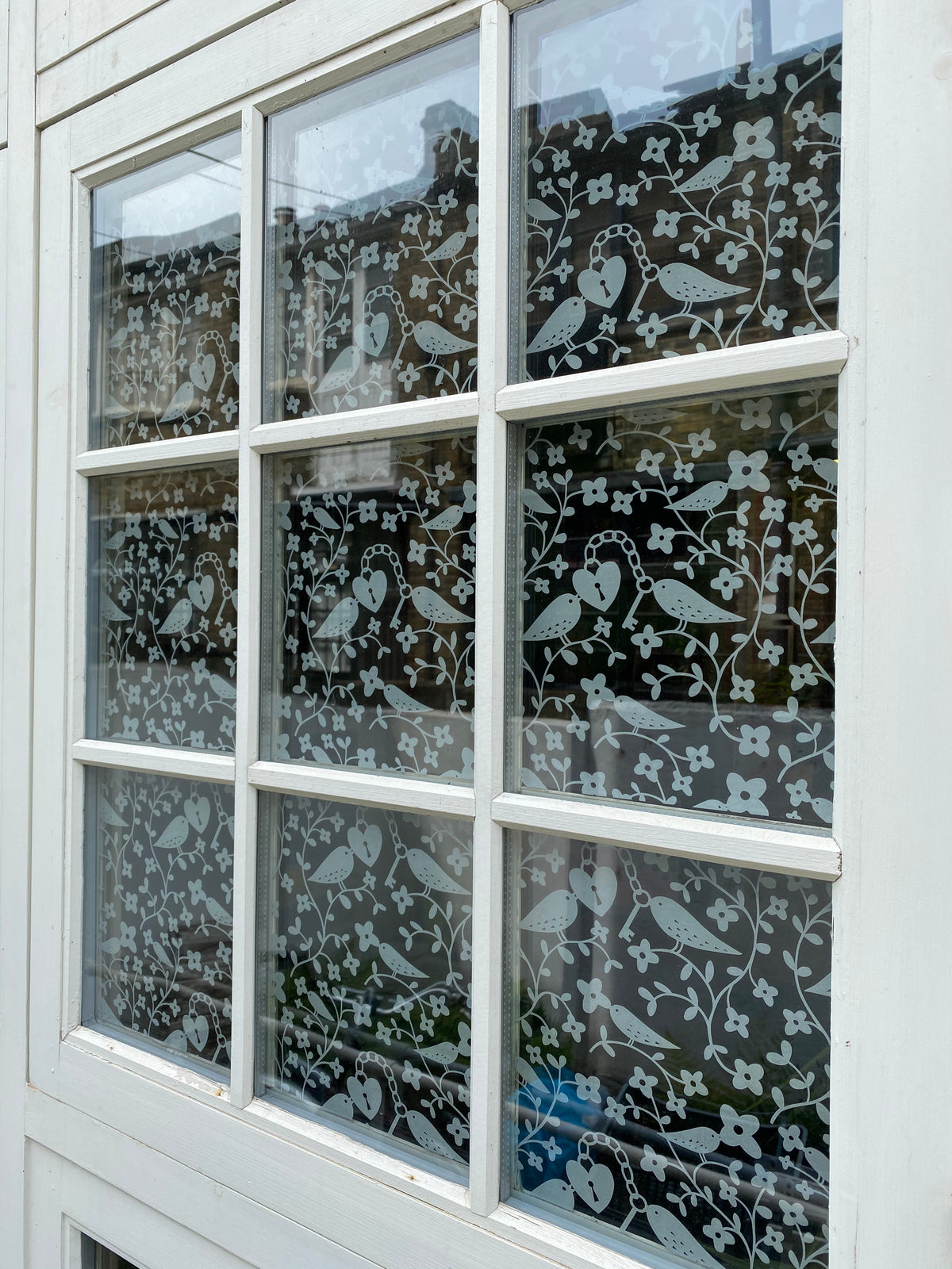 External view of a window split into multiple panes with frost on clear Rob Ryan window film applied to the glazing. 