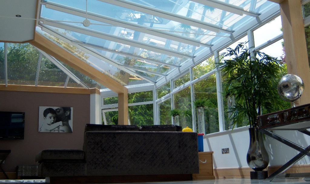A glass conservatory with heat reduction window film applied to the roof on the inside.