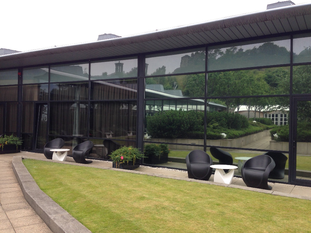 Silver reflective window film on the glass of a hotel for heat reduction.