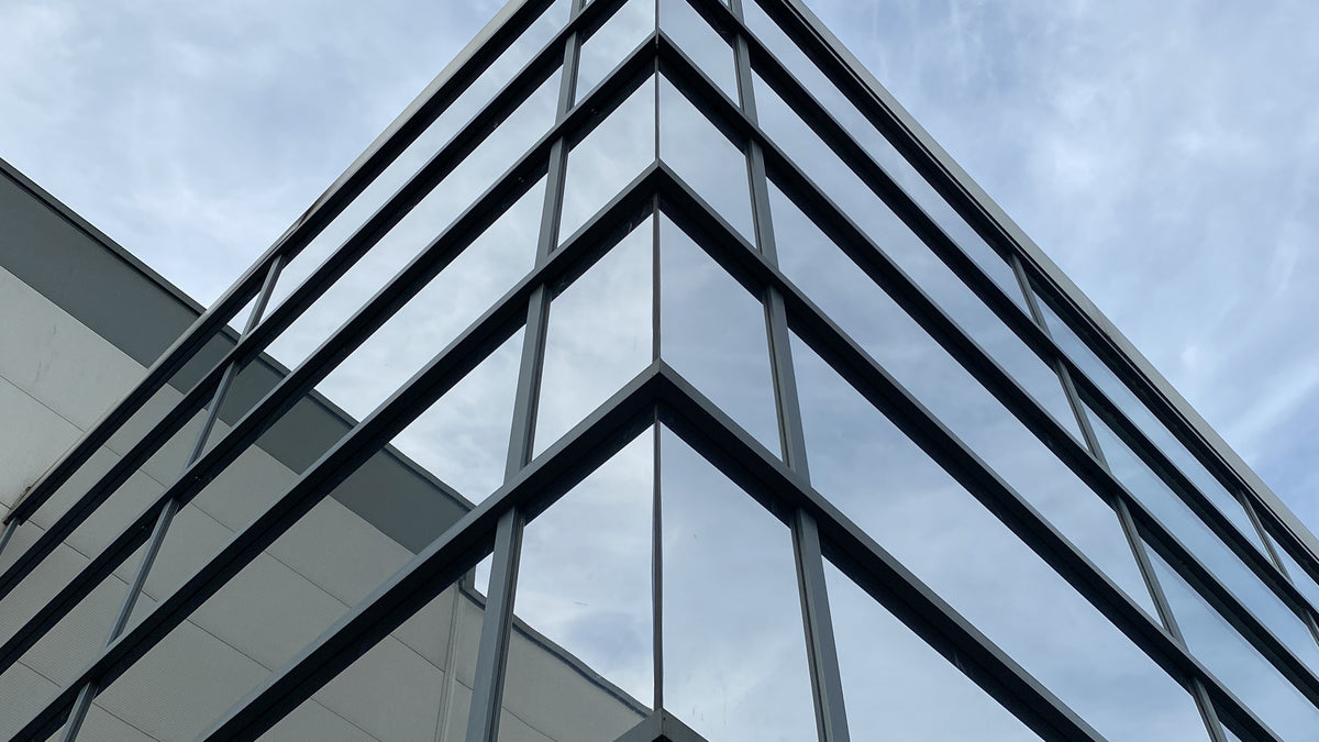 Close up corner of a glass building with solar control window film applied.