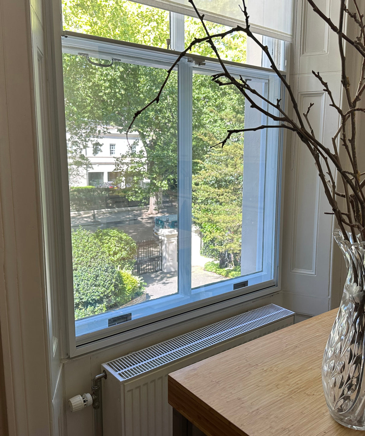A window in a residential property looking out onto a street scene. Solar control window film is applied to the glass.