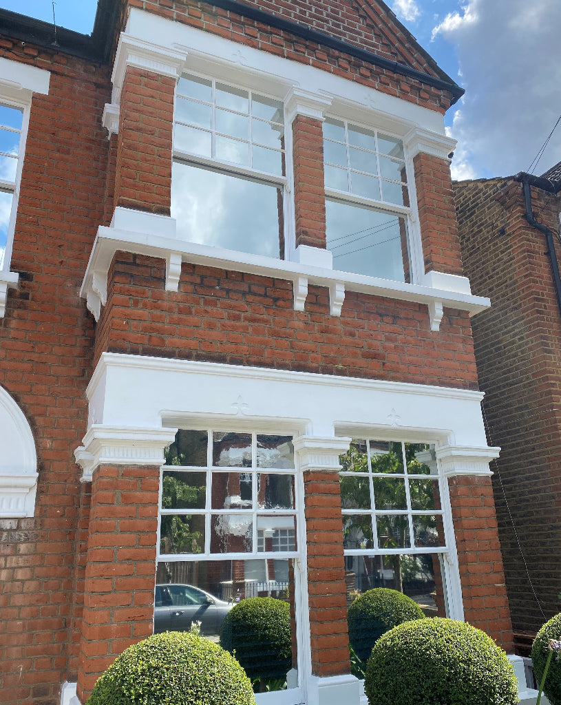 Solar control window film applied to the windows of a traditional brick house to reduce heat and glare.
