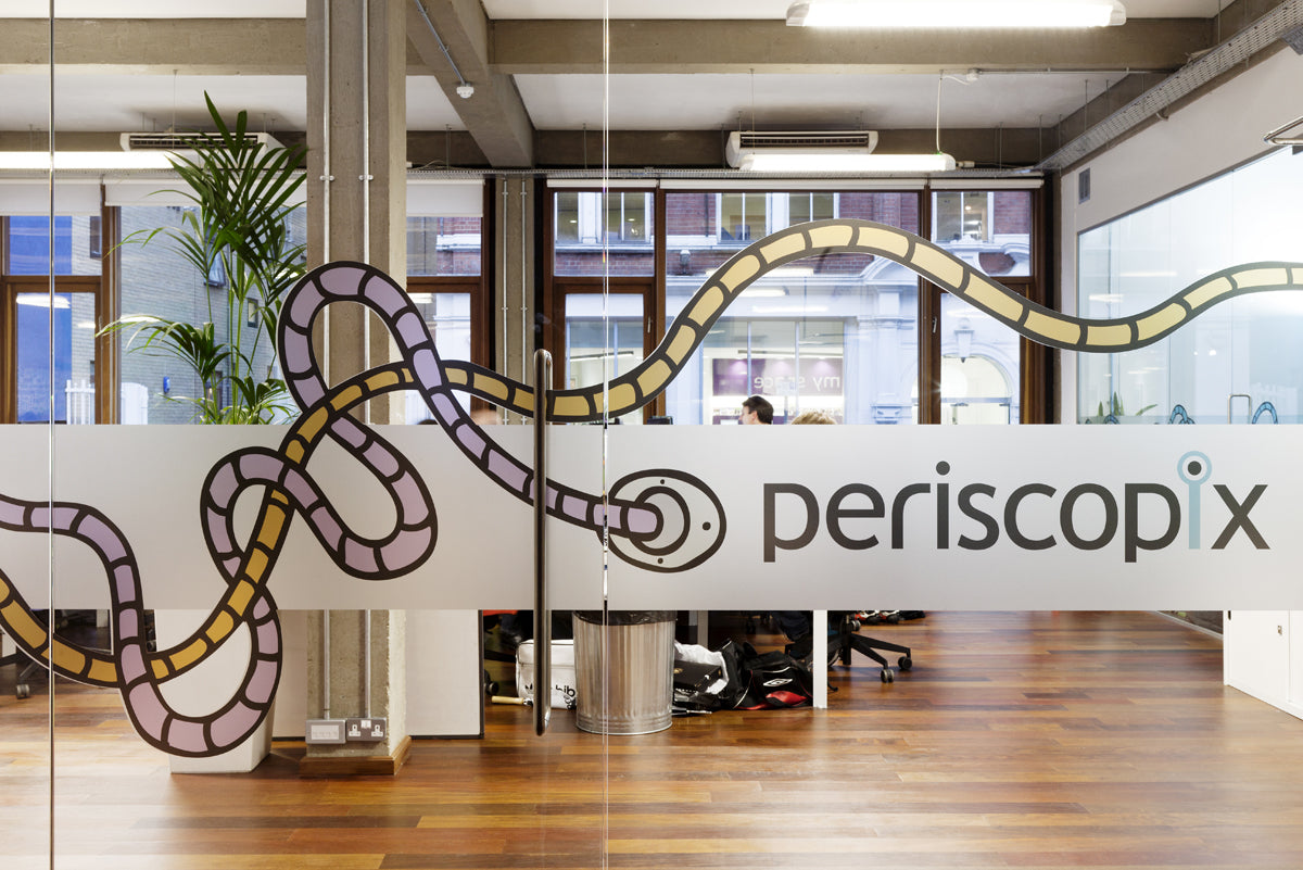 Modern office interior with Periscopix branding on a glass wall.