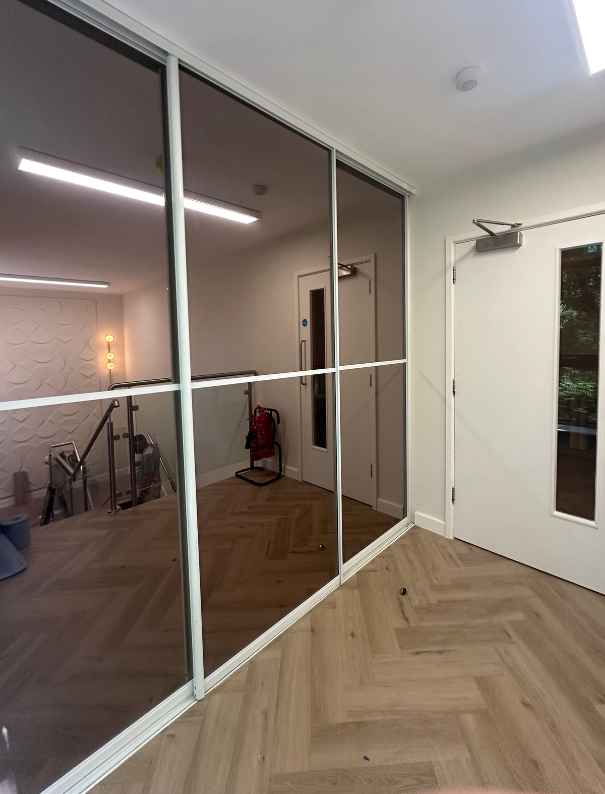 Large glazed panels with solar bronze window film applied, delivering a reflective appearance with a stylish bronze finish