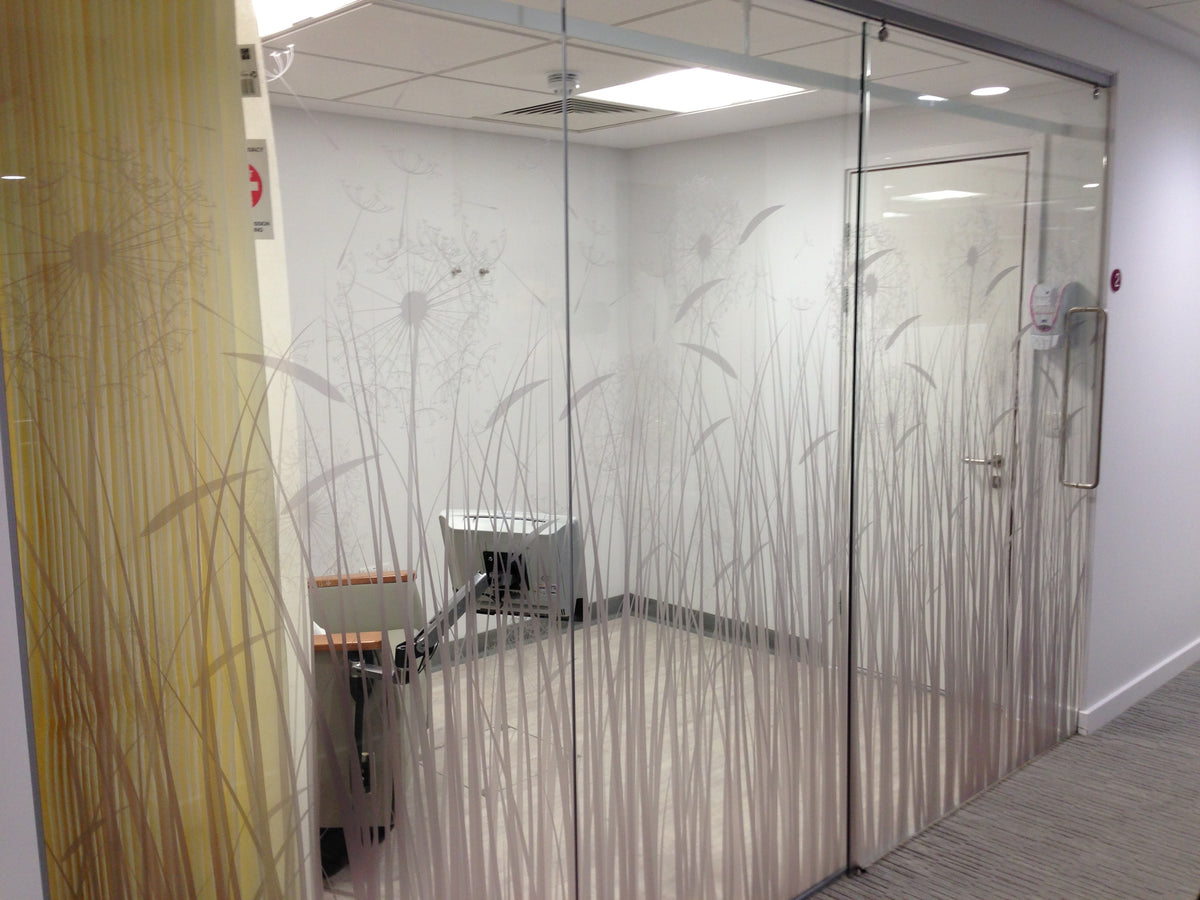 Glass partition with decorative nature design installed.