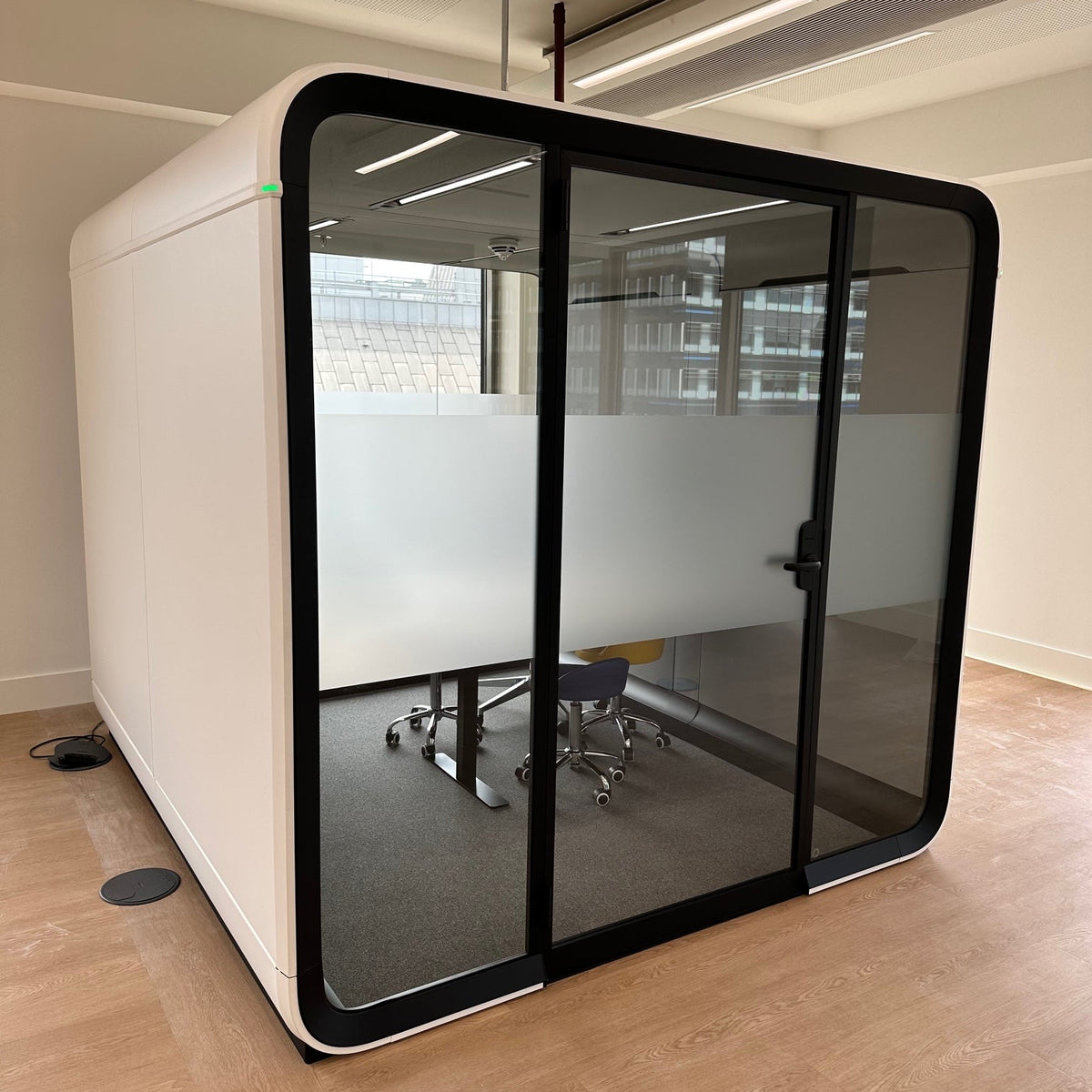Modern office pod with glass walls and a band of frosted manifestation to create privacy.