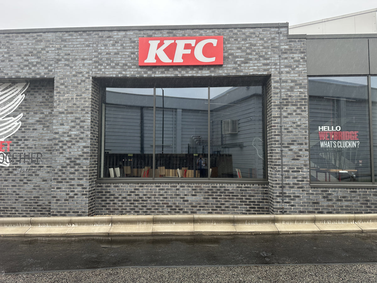 KFC restaurant exterior with brick facade and large window; the glazing has heat and glare reduction window film applied to it. 