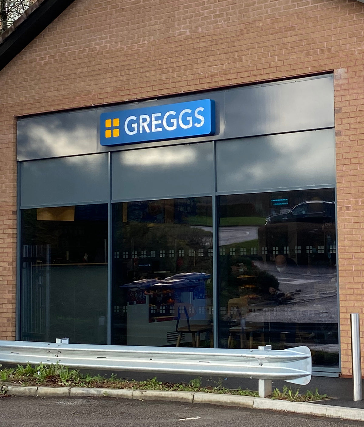 An external view of a branch of Greggs with solar control window film and manifestation markings applied to the glass.