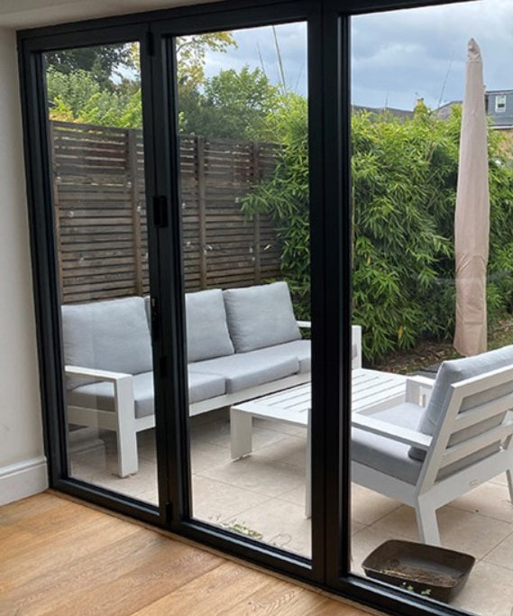 Modern patio doors pictured from the inside, looking out into a garden scene. The glass has Optiview window film applied to reduce excess heat and to bring down glare levels.