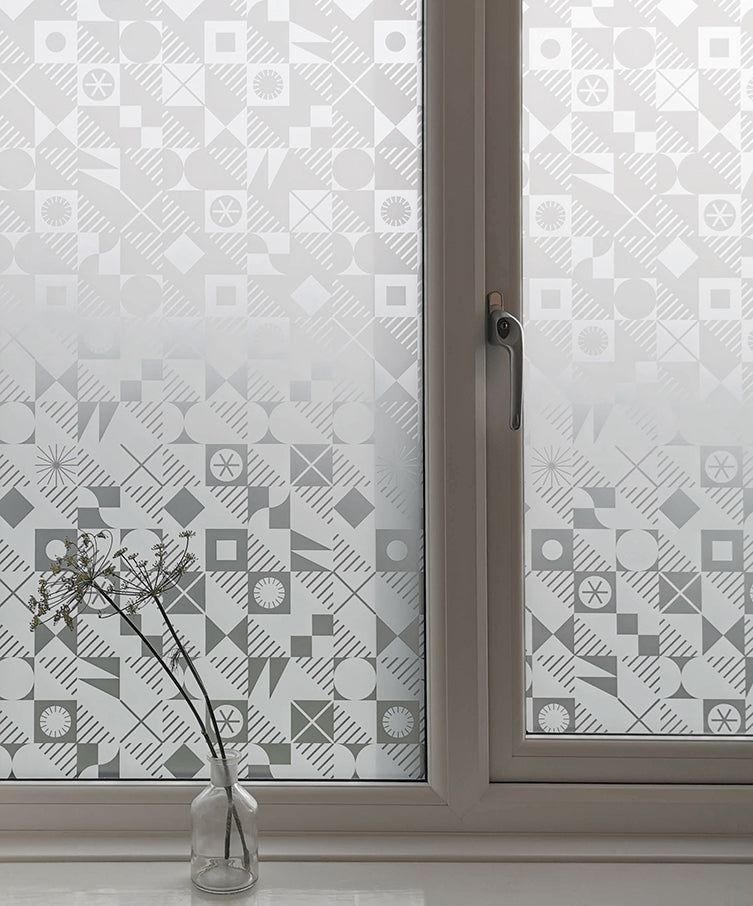 A window in a residential property featuring a designer window film by Kate Farley called Pairings. It is a repeated, modern pattern and has been installed to provide privacy.