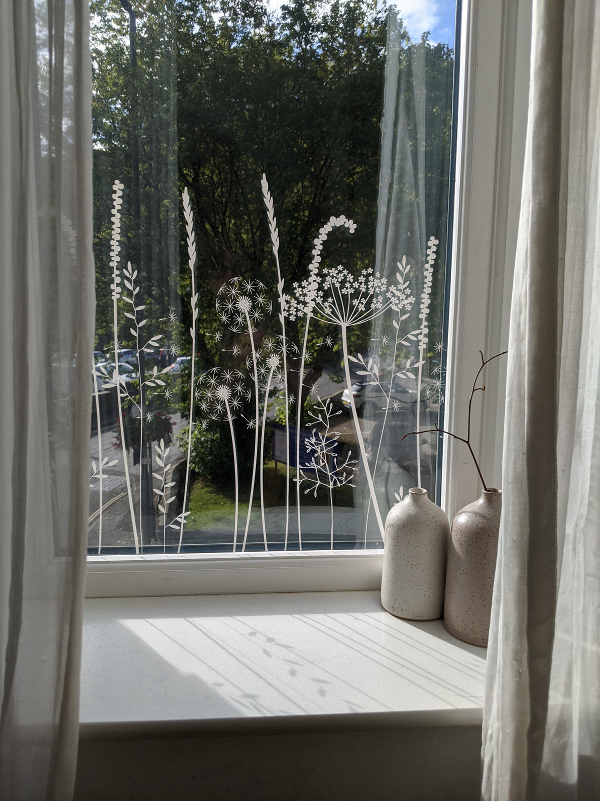 Decorative window film design that shows etched flowers and plants.