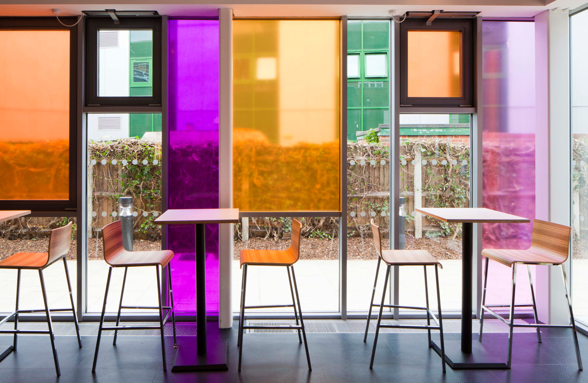 A modern interior in Watford, with coloured window film applied to different sized panes. The colours featured are shades of orange and purple.