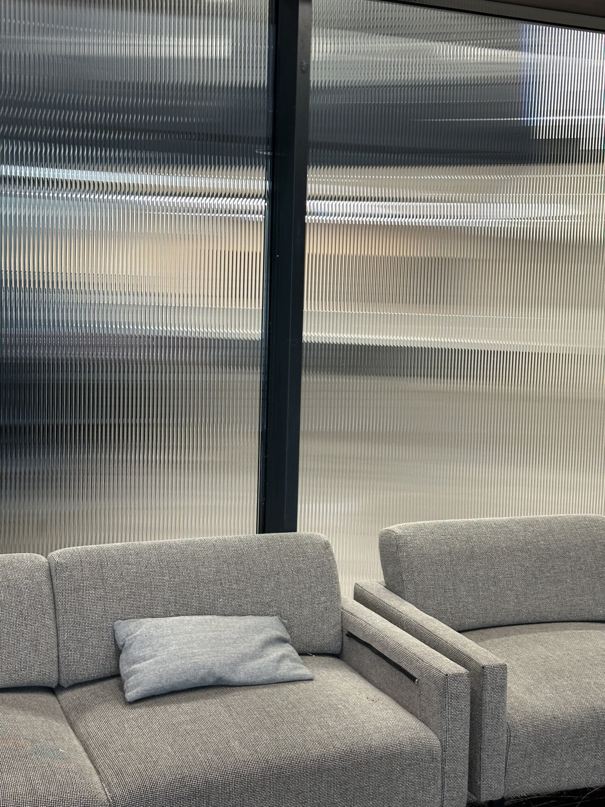 Reeded window film fitted to glass windows in a seating area.  The decorative film obscures vision.